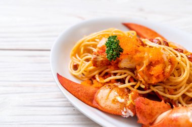 Beyaz tabakta karides yumurtalı ıstakoz spagettisi.