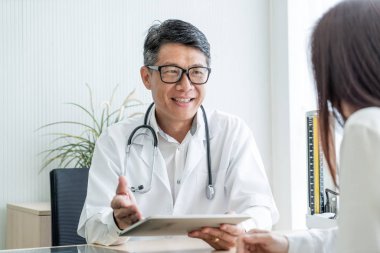 Asya kıdemli doktor ve hasta bir şey masada otururken görüşüyorlar