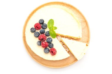 Ahududu ve beyaz arka plan üzerinde izole yaban mersini ile ev yapımı cheesecake