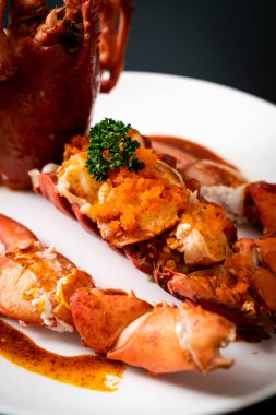 Soslu ıstakoz kuyruklu biftek ve beyaz arka planda karides yumurtaları.