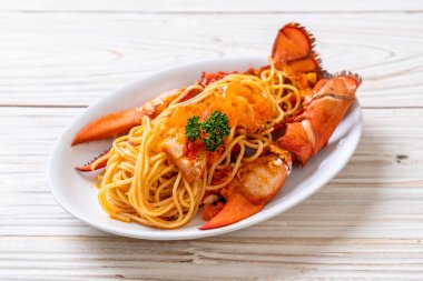 Beyaz tabakta karides yumurtalı ıstakoz spagettisi.