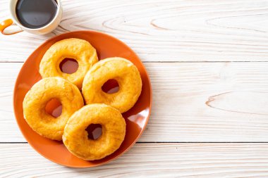 ahşap arka plan üzerinde siyah kahve ile çörek