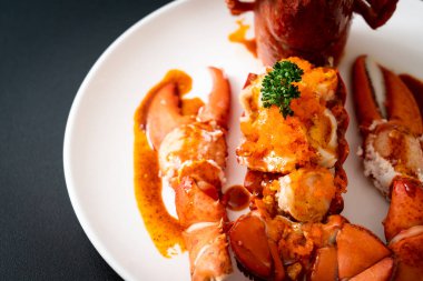 Soslu ıstakoz kuyruklu biftek ve beyaz arka planda karides yumurtaları.