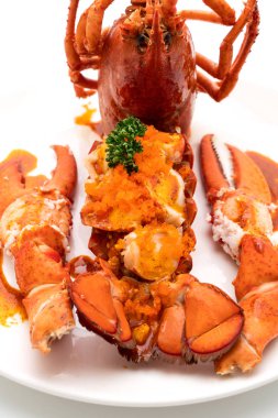 Soslu ıstakoz kuyruklu biftek ve beyaz arka planda karides yumurtaları.