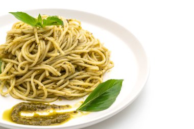 Homamade spagetti pesto sos, zeytin yağı ve beyaz arka plan üzerinde izole fesleğen yaprakları ile