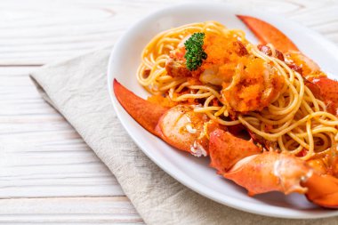 Beyaz tabakta karides yumurtalı ıstakoz spagettisi.