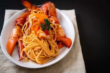 Beyaz tabakta karides yumurtalı ıstakoz spagettisi.