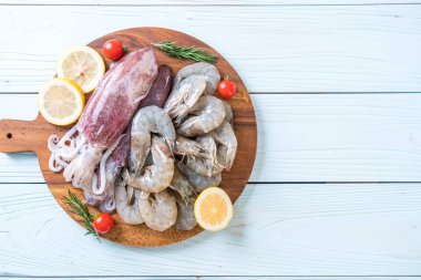 taze deniz ürünleri ham (karides, mürekkep) malzemelerle ahşap tahta üzerinde