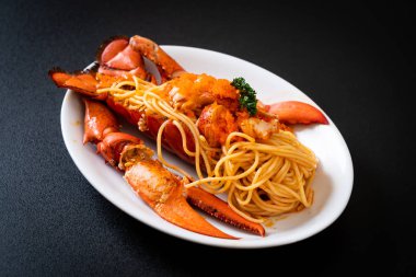 Beyaz tabakta karides yumurtalı ıstakoz spagettisi.