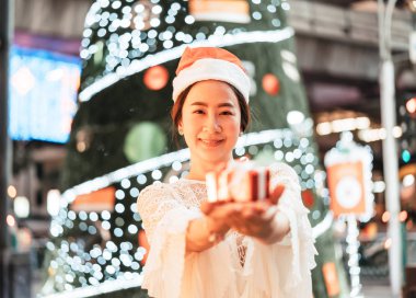 hediye şenlikli Noel Fuarı - vintage etkisi filtre ile gülümseyen güzel genç Asyalı kadın portresi