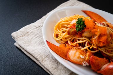 Beyaz tabakta karides yumurtalı ıstakoz spagettisi.