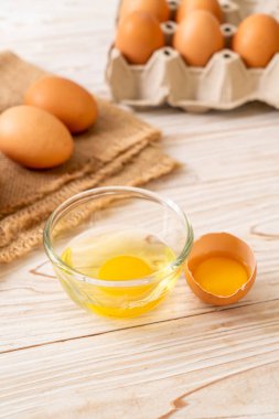 Ahşap masa üzerinde yumurta ile bir kırık kahverengi ve yumurta sarısı