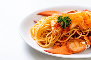 Beyaz tabakta karides yumurtalı ıstakoz spagettisi.