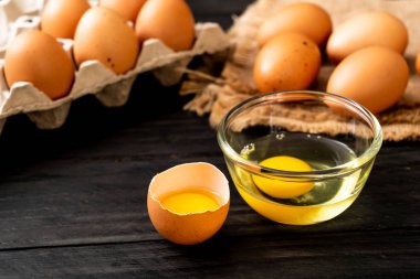 Ahşap masa üzerinde yumurta ile bir kırık kahverengi ve yumurta sarısı