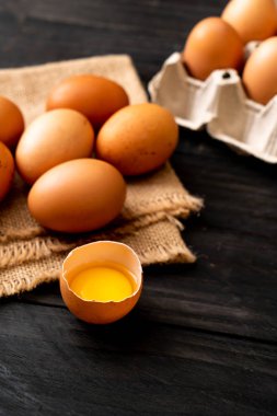 Ahşap masa üzerinde yumurta ile bir kırık kahverengi ve yumurta sarısı