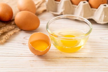 Ahşap masa üzerinde yumurta ile bir kırık kahverengi ve yumurta sarısı