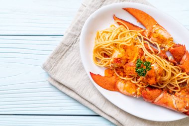 Beyaz tabakta karides yumurtalı ıstakoz spagettisi.