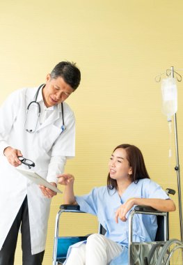 Tekerlekli sandalye ile kıdemli Doktor Asyalı kadın hastayı