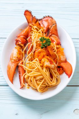 Beyaz tabakta karides yumurtalı ıstakoz spagettisi.