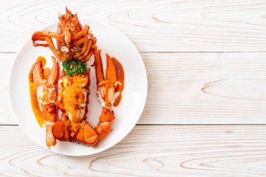 Soslu ıstakoz kuyruklu biftek ve beyaz arka planda karides yumurtaları.