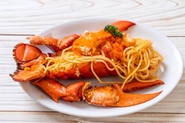 Beyaz tabakta karides yumurtalı ıstakoz spagettisi.