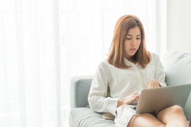 Güzel Asyalı kadın evde laptop ve telefon ile çalışma