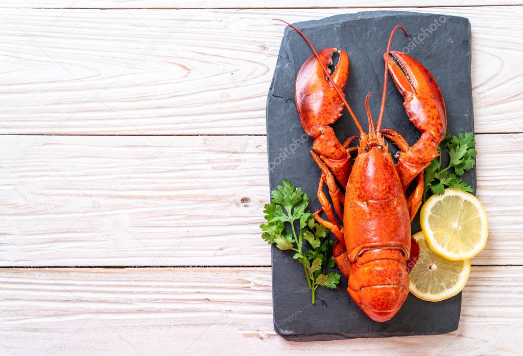 red lobster with vegetable and lemon on black slate plate