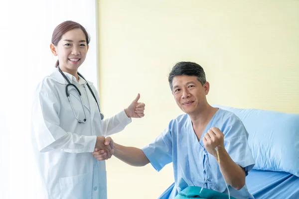 病院や診療所の Hre の患者 医療とプロフェッショナ リズムの概念に 握手を与えることでアジアの女性医師 — ストック写真
