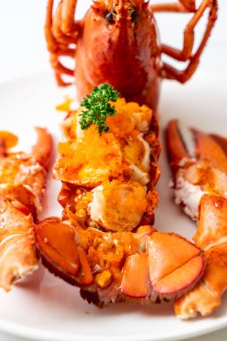 Soslu ıstakoz kuyruklu biftek ve beyaz arka planda karides yumurtaları.