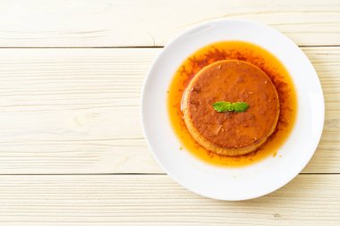 Ev yapımı karamel kremalı puding ahşap arka plan üzerinde