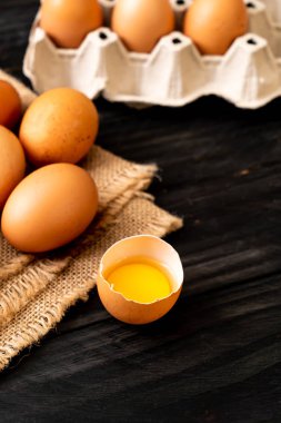 Ahşap masa üzerinde yumurta ile bir kırık kahverengi ve yumurta sarısı
