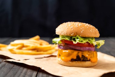 taze lezzetli biftek burger peynir ve patates kızartması ahşap arka plan üzerinde