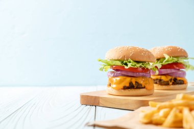 taze lezzetli biftek burger peynir ve patates kızartması ahşap arka plan üzerinde