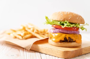 taze lezzetli biftek burger peynir ve patates kızartması ahşap arka plan üzerinde