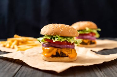 taze lezzetli biftek burger peynir ve patates kızartması ahşap arka plan üzerinde