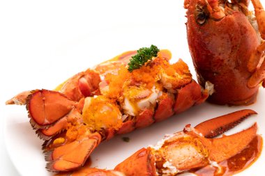 Soslu ıstakoz kuyruklu biftek ve beyaz arka planda karides yumurtaları.