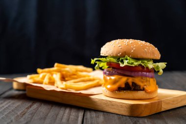 taze lezzetli biftek burger peynir ve patates kızartması ahşap arka plan üzerinde