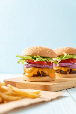 taze lezzetli biftek burger peynir ve patates kızartması ahşap arka plan üzerinde