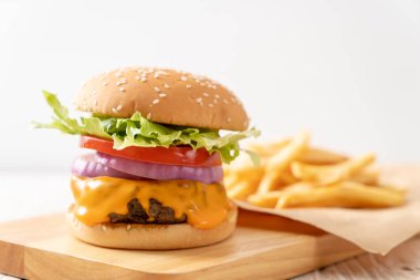 taze lezzetli biftek burger peynir ve patates kızartması ahşap arka plan üzerinde