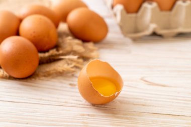 Ahşap masa üzerinde yumurta ile bir kırık kahverengi ve yumurta sarısı