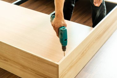 mobilya yapmak için matkap tutan el