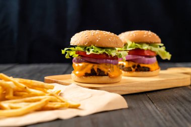 taze lezzetli biftek burger peynir ve patates kızartması ahşap arka plan üzerinde