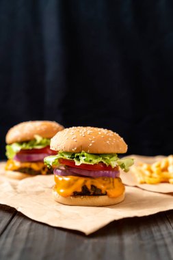 taze lezzetli biftek burger peynir ve patates kızartması ahşap arka plan üzerinde