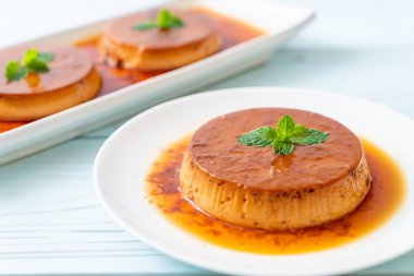 Ev yapımı karamel kremalı puding ahşap arka plan üzerinde