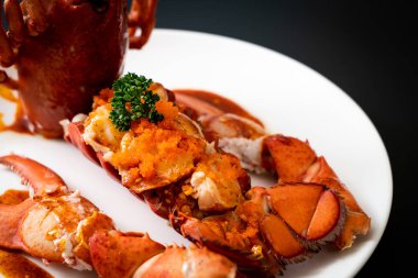 Soslu ıstakoz kuyruklu biftek ve beyaz arka planda karides yumurtaları.