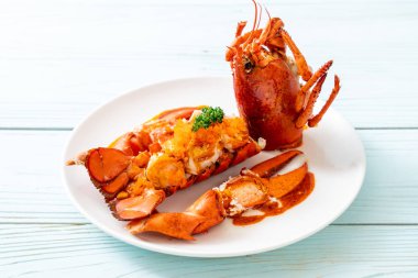 Soslu ıstakoz kuyruklu biftek ve beyaz arka planda karides yumurtaları.