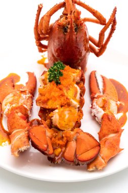 Soslu ıstakoz kuyruklu biftek ve beyaz arka planda karides yumurtaları.