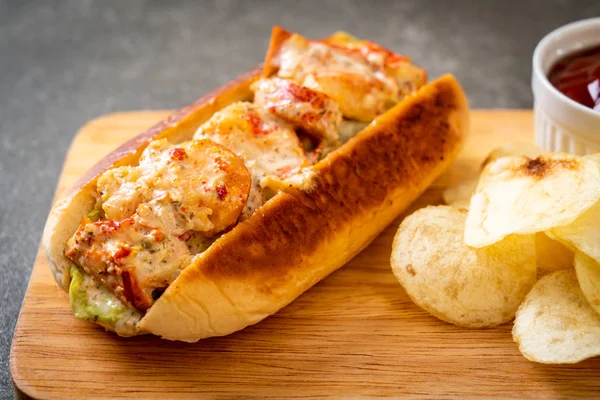 homemade lobster roll with potato chips on wooden board