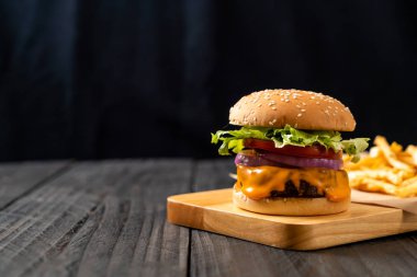 taze lezzetli biftek burger peynir ve patates kızartması ahşap arka plan üzerinde