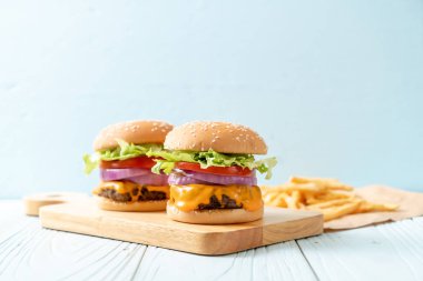 taze lezzetli biftek burger peynir ve patates kızartması ahşap arka plan üzerinde